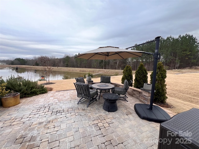 view of patio featuring a water view and a fire pit