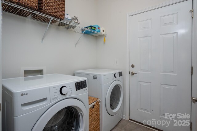 clothes washing area with washing machine and dryer