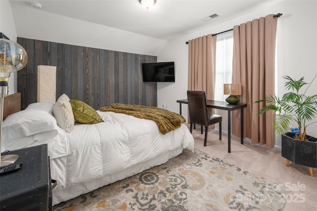 carpeted bedroom featuring lofted ceiling and wooden walls