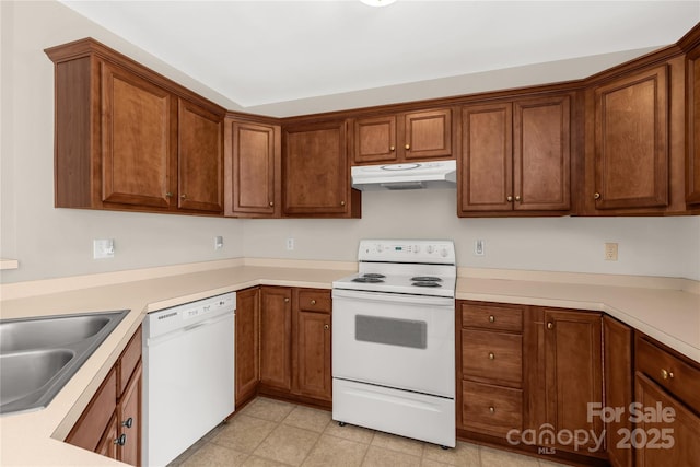 kitchen featuring brown cabinets, white appliances, under cabinet range hood, and light countertops