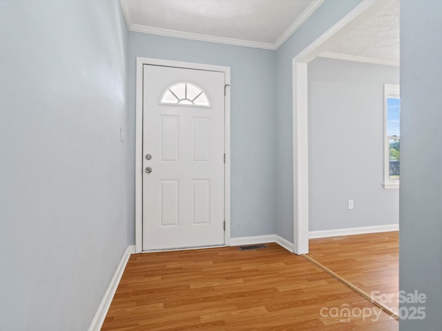 entryway featuring ornamental molding and light hardwood / wood-style floors