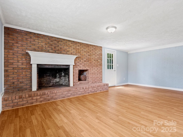 unfurnished living room featuring light hardwood / wood-style flooring, crown molding, a fireplace, and a textured ceiling