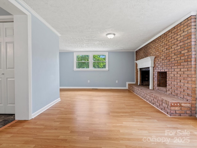 unfurnished living room with a fireplace, light hardwood / wood-style flooring, ornamental molding, and a textured ceiling