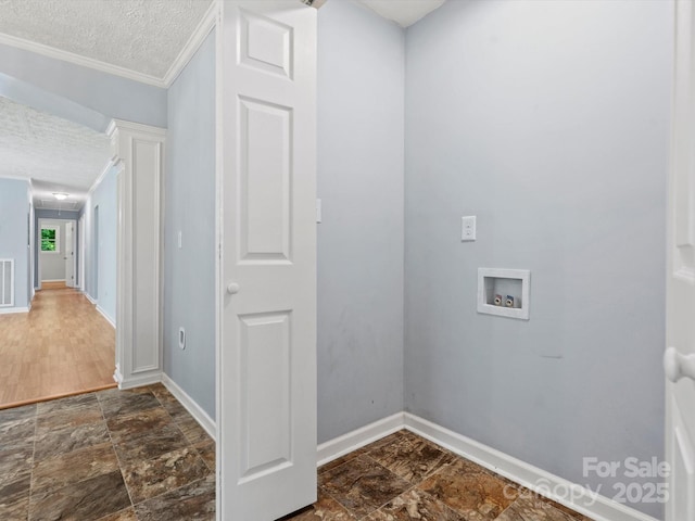 laundry area with hookup for a washing machine, ornamental molding, and a textured ceiling