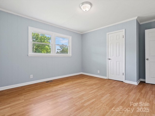 unfurnished bedroom featuring crown molding and light wood-type flooring