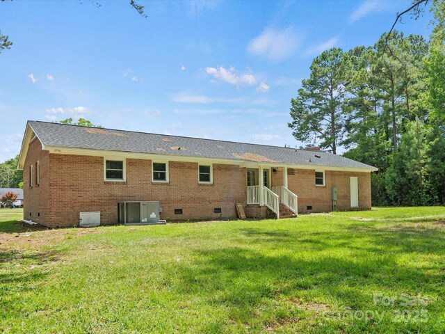 back of property with cooling unit and a yard