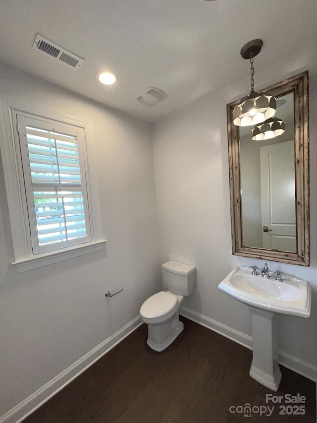 bathroom featuring hardwood / wood-style flooring and toilet