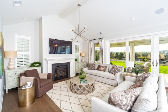 living room with vaulted ceiling with beams, a chandelier, and light wood-type flooring