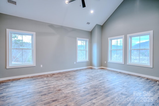 empty room with ceiling fan, high vaulted ceiling, and hardwood / wood-style floors