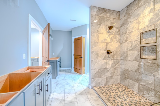 bathroom with vanity and tiled shower