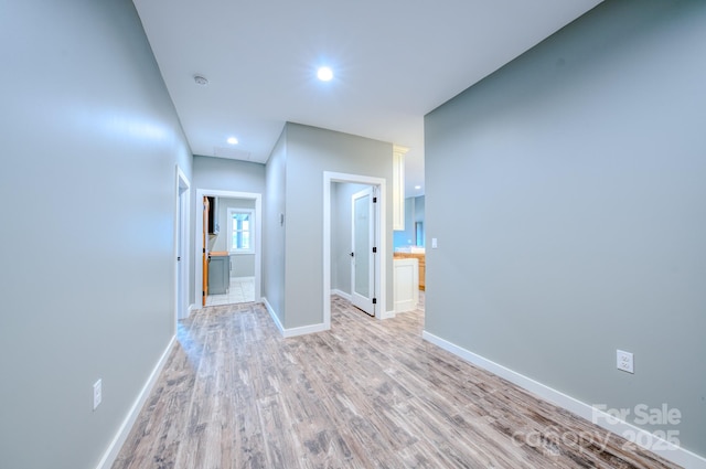 hallway with light hardwood / wood-style floors