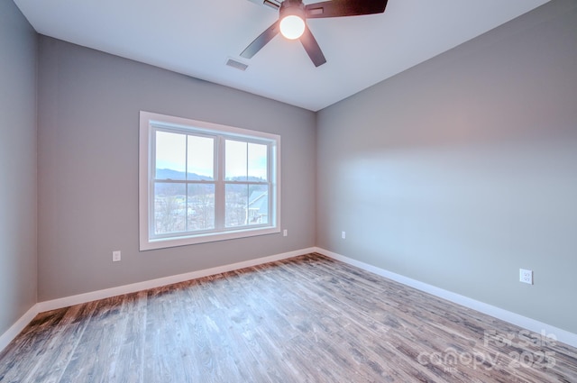 empty room featuring hardwood / wood-style floors and ceiling fan