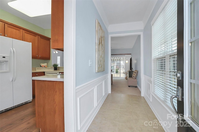 kitchen featuring white refrigerator with ice dispenser and ornamental molding