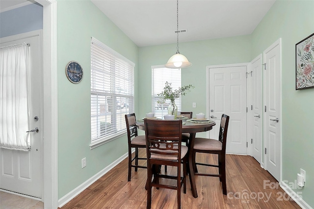 dining space with wood-type flooring