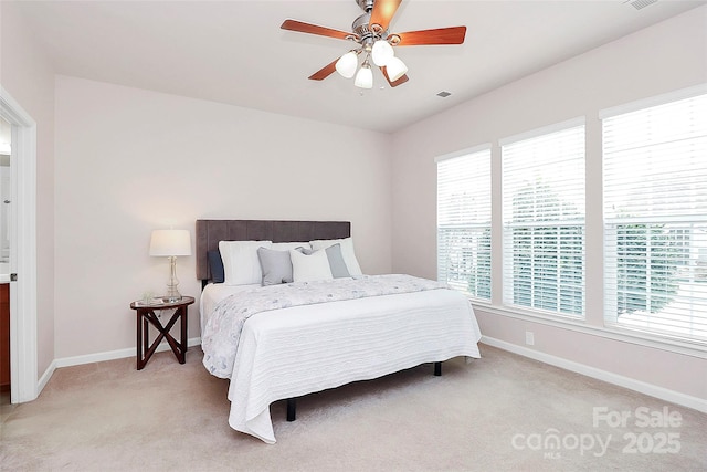 bedroom with multiple windows, light carpet, and ceiling fan