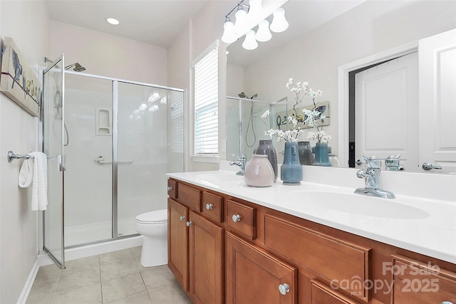 bathroom with tile patterned flooring, vanity, a shower with door, and toilet