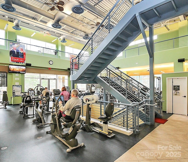 gym with a towering ceiling and ceiling fan