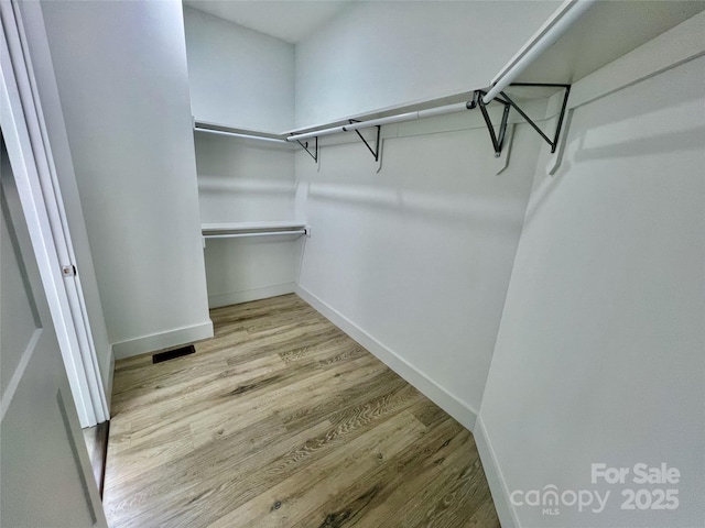 spacious closet with light hardwood / wood-style flooring