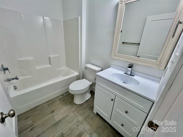 full bathroom featuring bathing tub / shower combination, hardwood / wood-style floors, vanity, and toilet