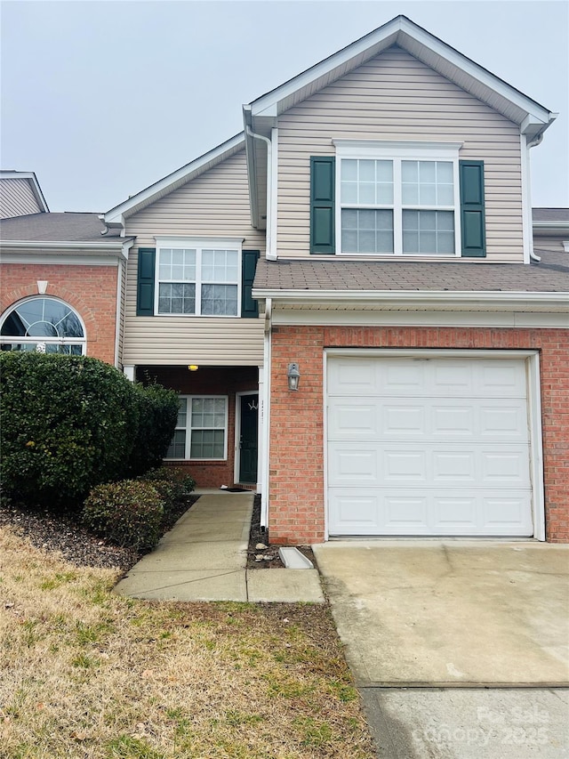 view of front facade featuring driveway, a garage, and brick siding