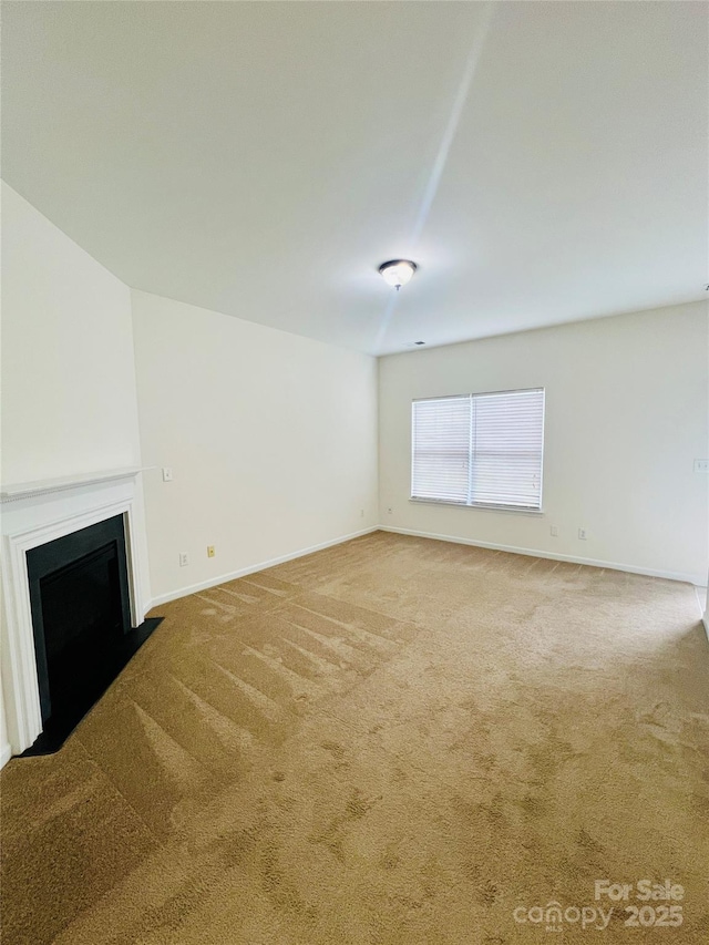 unfurnished living room with a fireplace with flush hearth, carpet floors, and baseboards