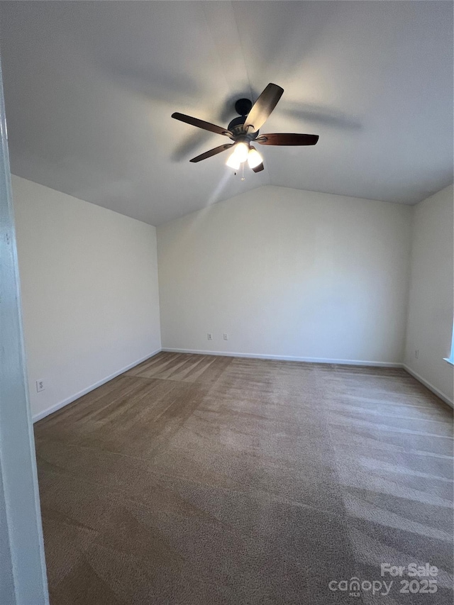 carpeted empty room featuring lofted ceiling, ceiling fan, and baseboards