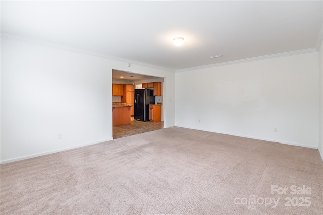 unfurnished living room with ornamental molding and light carpet