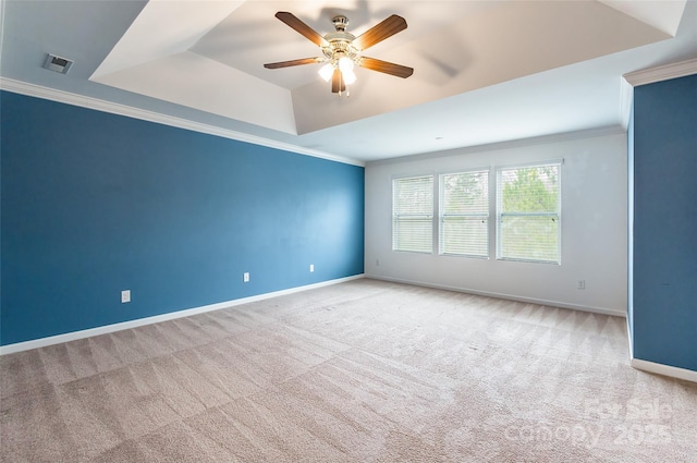 unfurnished room featuring a raised ceiling, crown molding, light colored carpet, and ceiling fan