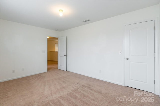 unfurnished room featuring light carpet