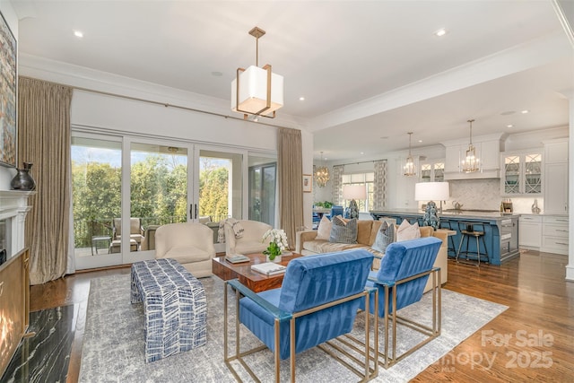 living room featuring ornamental molding, dark wood finished floors, a notable chandelier, and french doors