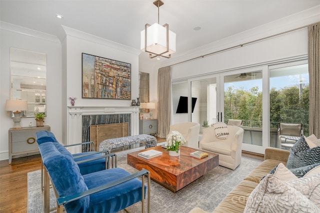 living room featuring a fireplace, crown molding, and wood finished floors