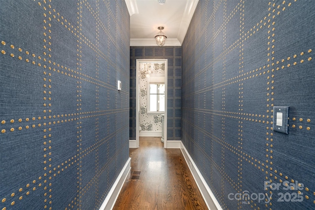 corridor featuring crown molding, visible vents, wood finished floors, baseboards, and wallpapered walls