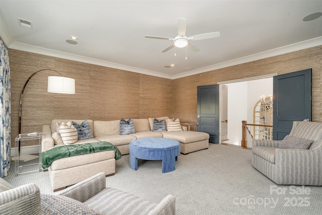 carpeted living room featuring a ceiling fan and crown molding