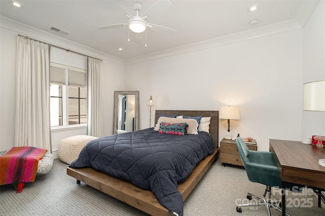 carpeted bedroom featuring ornamental molding, visible vents, and a ceiling fan