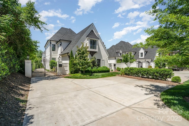 1328 S Kings Dr, Charlotte, NC 28207 - view of front of property featuring a gate, stucco siding, a shingled roof, and concrete driveway