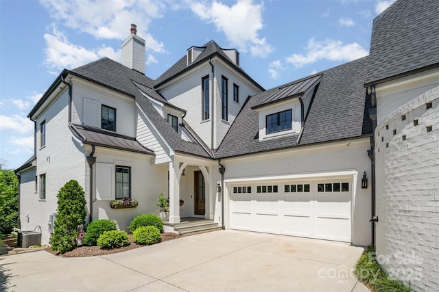 1328 S Kings Dr, Charlotte, NC 28207 - french country style house with driveway, a shingled roof, a standing seam roof, a chimney, and a garage
