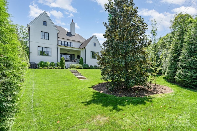 1328 S Kings Dr, Charlotte, NC 28207 - back of property with a yard, a chimney, stucco siding, and ceiling fan