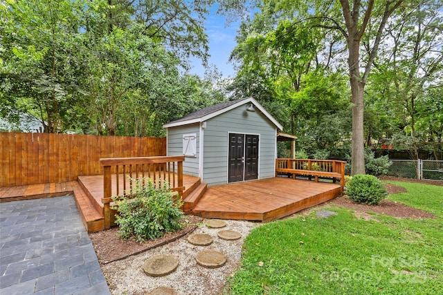 wooden deck featuring a storage shed and a yard