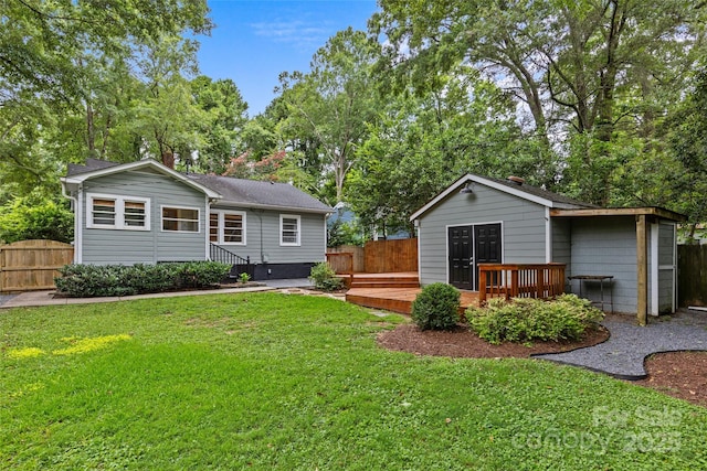 rear view of property featuring a wooden deck and a lawn