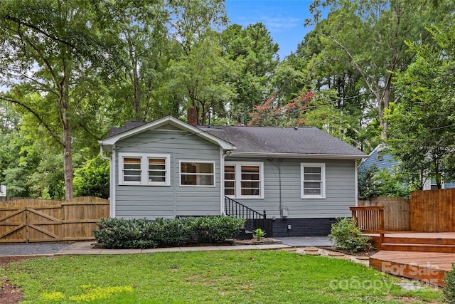 back of house with a wooden deck and a yard