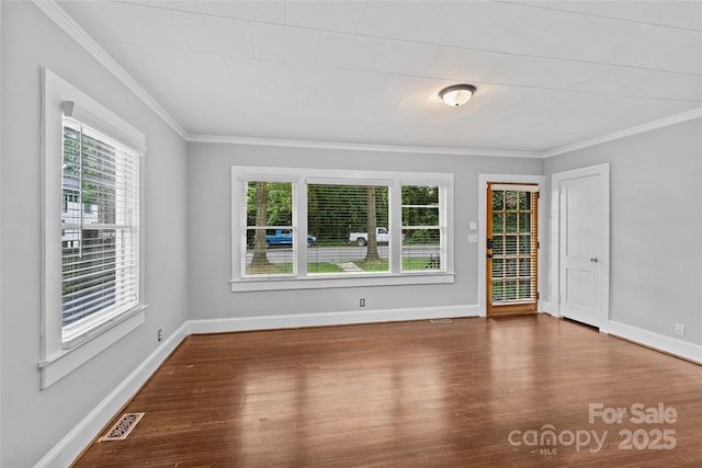 spare room with ornamental molding, plenty of natural light, and hardwood / wood-style floors