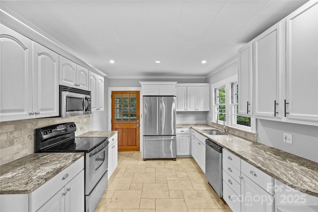 kitchen featuring sink, appliances with stainless steel finishes, white cabinetry, tasteful backsplash, and light stone countertops