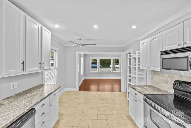 kitchen featuring light stone countertops, crown molding, stainless steel appliances, and white cabinets