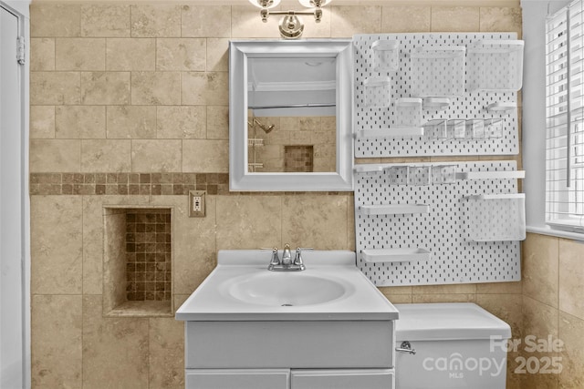 bathroom with vanity, tile walls, and toilet