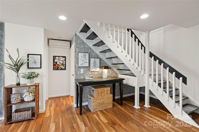 stairs with hardwood / wood-style floors and a wall unit AC