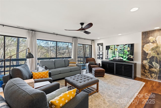 living room with wood-type flooring and ceiling fan