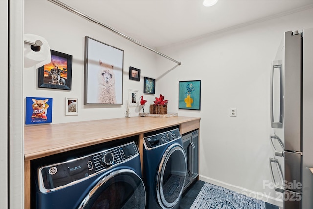 laundry room featuring crown molding and washer and dryer