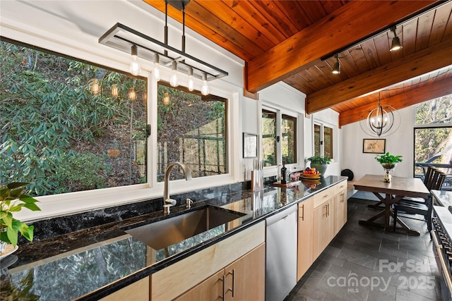 kitchen featuring light brown cabinetry, sink, decorative light fixtures, dark stone countertops, and dishwasher