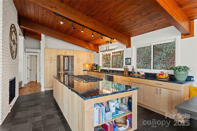 kitchen with appliances with stainless steel finishes, a center island, light brown cabinetry, and decorative light fixtures