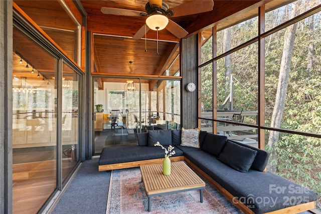 unfurnished sunroom featuring ceiling fan, vaulted ceiling, a healthy amount of sunlight, and wood ceiling